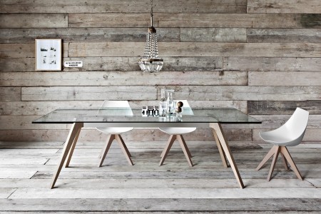 The Pianca Delta Dining Table rests on a central extended timber. The table’s beauty and balance is emphasized by the glassy and transparent surface. It shines on oak trestle legs.