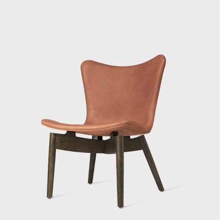 The Mater Shell Lounge Chair has a contemporary and elegant silhouette defined by the sculptural wooden frame and a  "floating seat" that creates an interaction of stability and dynamism. It has three wood frame options and a highly curated fabric and leather upholstery selection.